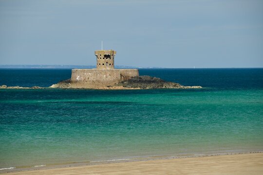 Jersey, U.K. 19th century Rocco Tower with Guernsey on the horizon in the Summer.