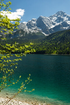 Travel landscape of Eibsee lake beach and Zugspitze peak in Alps, Bavaria Germany, scenic summer nature panorama with forest