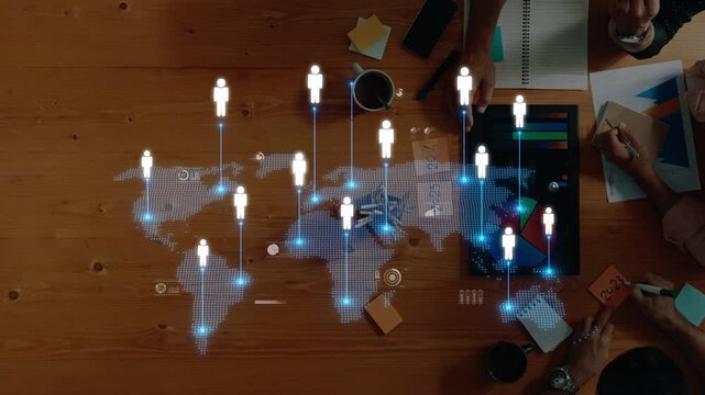An aerial view of a collaborative workspace featuring a digital map with human icons. Highlights the interconnectivity of teams in a global business environment. Raster