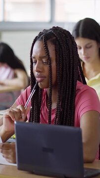 Focused African American female student taking exam at college classroom