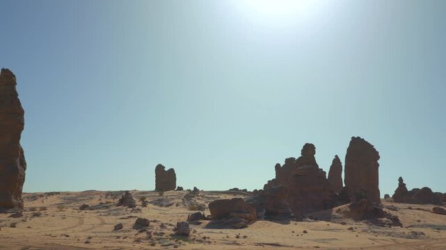 Unusual rocky columns or pillars in Saudi Arabia desert at Al Gharameel. Bright hot sun shines over sand and rocks desert, scene that looks like different planet