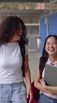 Asian and African American girl friends walking to College - Cheerful secondary school students going back to classes 