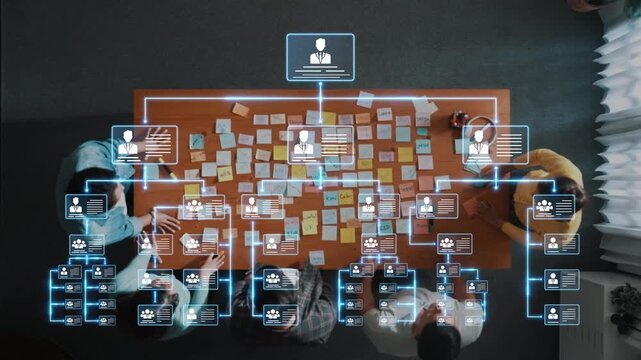 A top-down view of a collaborative workspace, illustrating a team engaged in a meeting with an organization chart and colorful sticky notes, showcasing dynamic teamwork. Raster