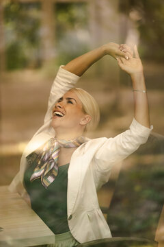 Woman Stretches and Smiles in Small Office During Work Hours