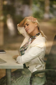 Woman Sitting in a Small Office and Taking a Break While Working on a Computer