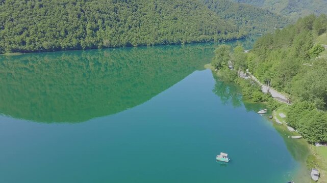 Aerial Drone View of Pliva Lake in Bosnia and Herzegovina with Emerald Green Water and Mountain Reflections
