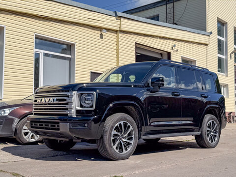 Black Haval H9 luxury off-road SUV wrapped in clear polyurethane anti-gravel film for paint protection, parked outdoors. Chinese premium 4x4 vehicle with glossy protective PPF wrap against chips. 