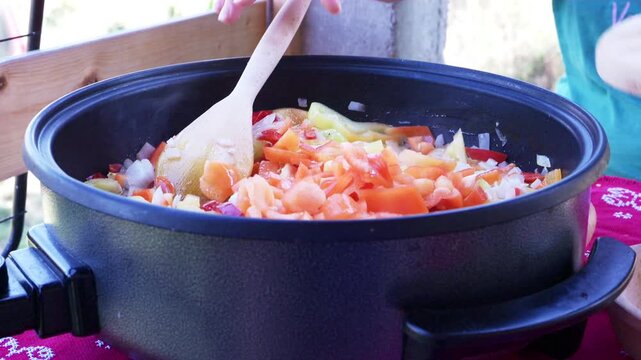 Saut&eacute;ed Vegetables Simmering in Skillet with Wooden Spoon