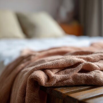 Soft linen blanket draped over wooden bench in cozy bedroom