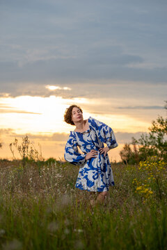 Woman in Blue Boho Dress Posing in Sunset Meadow