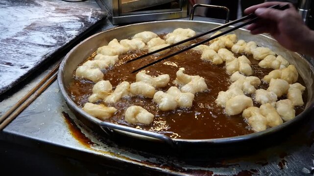 You tiao or Chinese Doughnut. Making Chinese deep-fried fluffy dough sticks.