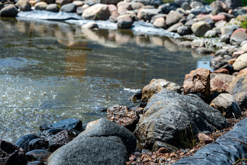 Obraz premium stone border, clear fresh water, and active aeration bubbles in a water feature. landscape background