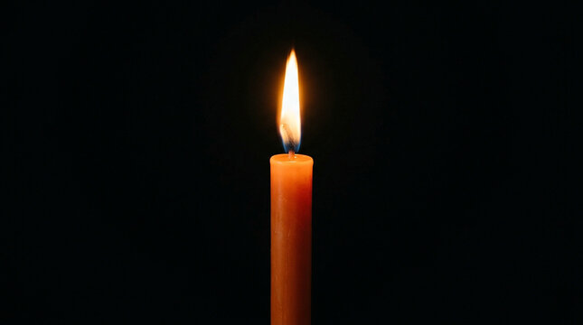 Single orange candle burning brightly against a dark background