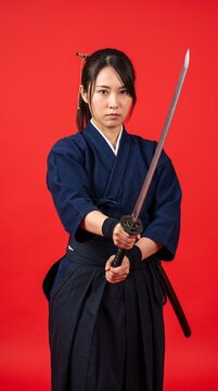 日本人女性の侍が刀を持って攻撃の構えをしている