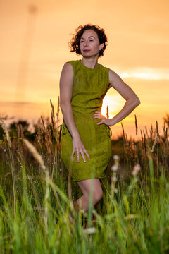 Woman in Green Dress at Sunset in Tall Grass