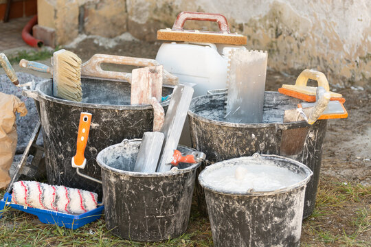 Home renovation with building materials, plaster, paint, and tools for interior construction and finishing work. Concept: providing construction, repair, and finishing services.