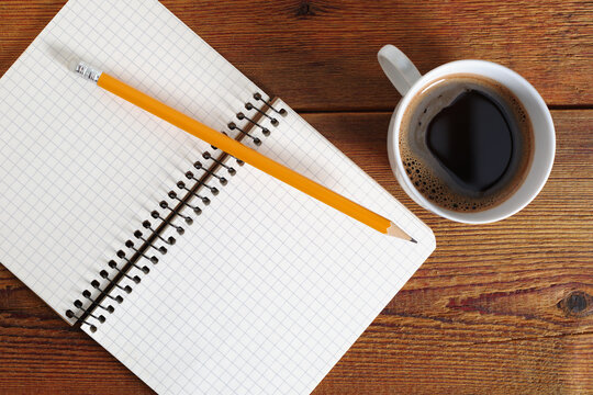 Open notebook, pencil, and coffee