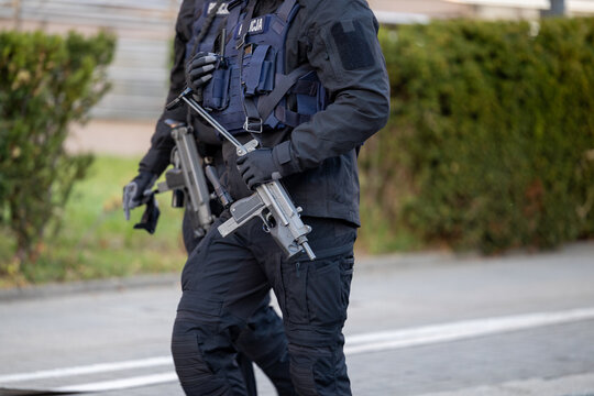 Policjant z karabinem automatycznym na patrolu. 
