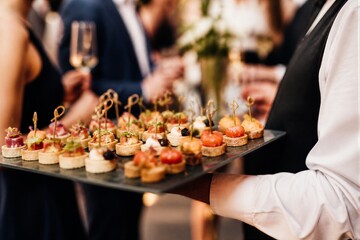 Fototapeta premium Waiter holding tray of canapes at cocktail reception
