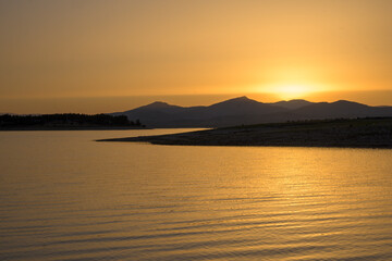 Golden sunset over mountain lake © MiguelA