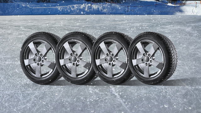 Set of winter tires on alloy wheels, standing on the ice.