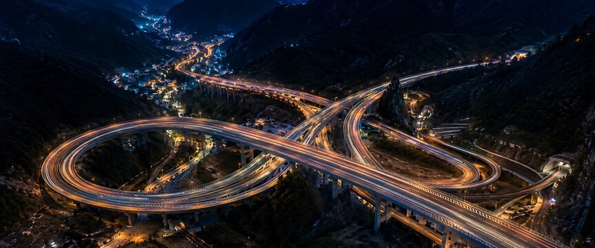 Complex highway interchange at night with light trails from vehicles during dusk