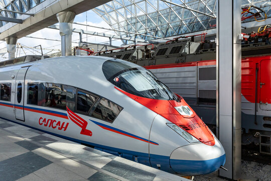 High-speed Sapsan train at Leningradsky railway station terminal in Moscow with glass roof and additional trains visible in the background, showcasing advanced transportation technology