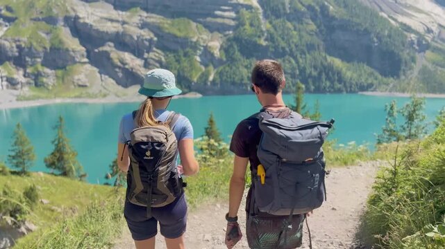 Oeschinen Lake, Switzerland - August 14, 2026: Tourists hiking along the lake with views of the Swiss Alps