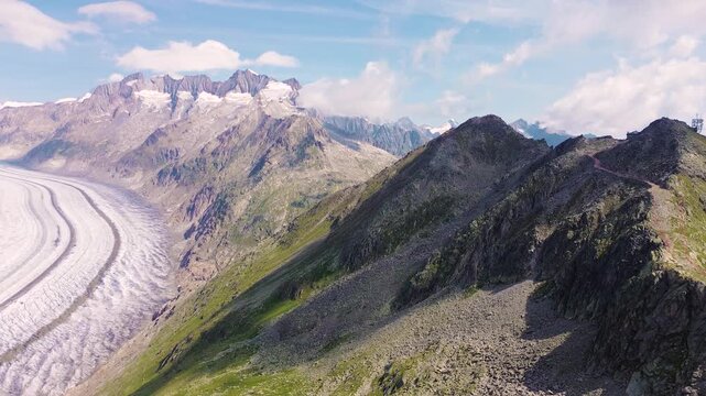Aerial drone view of the Great Aletsch Glacier surrounded by the Swiss Alps from a mountain summit