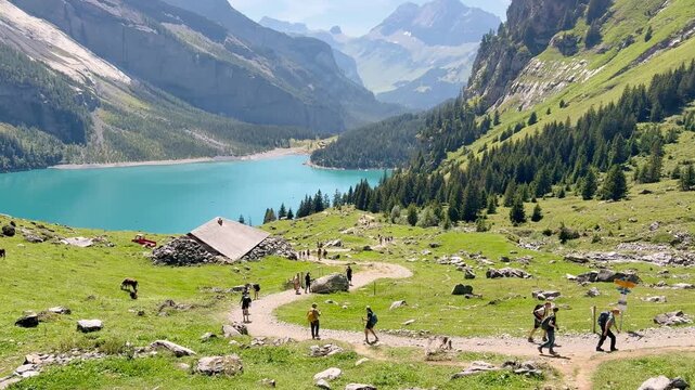 Tourists hiking along the lake with views of the Swiss Alps