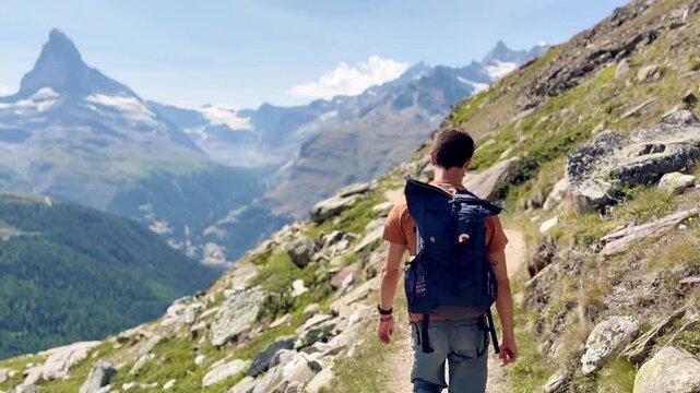 Tourists hiking along the lake with views of the Swiss Alps