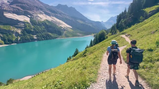 Oeschinen Lake, Switzerland - August 14, 2026: Tourists hiking along the lake with views of the Swiss Alps