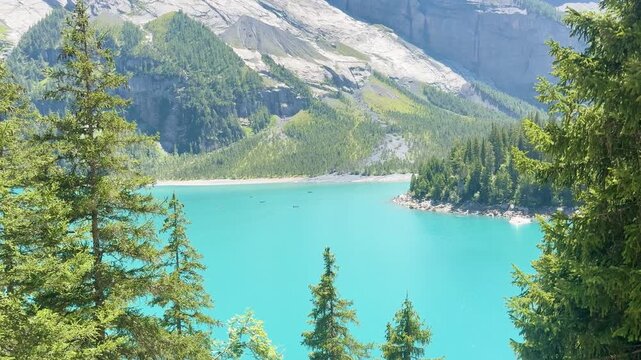 Tourists hiking along the lake with views of the Swiss Alps