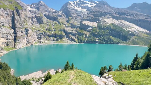 Tourists hiking along the lake with views of the Swiss Alps