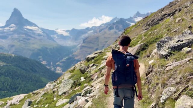 Tourists hiking along the lake with views of the Swiss Alps