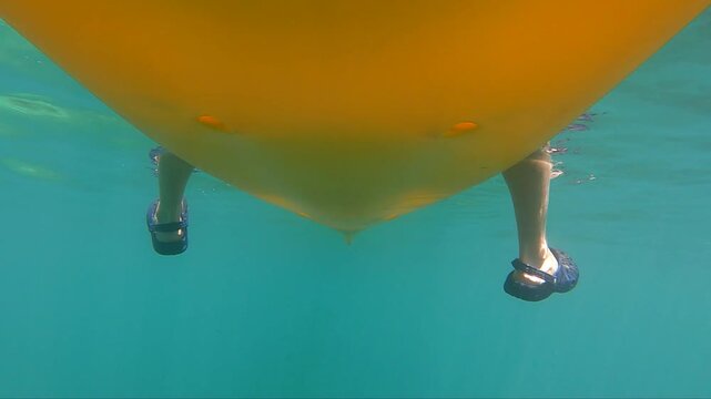 Kayaker fishing underwater as a fish strikes a lure in clear water