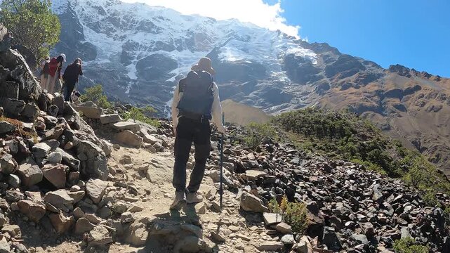 Hiker trekking through the Andes with mountain and Humantay Lake views near Machu Picchu, Peru