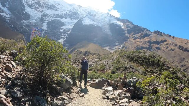 Hiker trekking through the Andes with mountain and Humantay Lake views near Machu Picchu, Peru