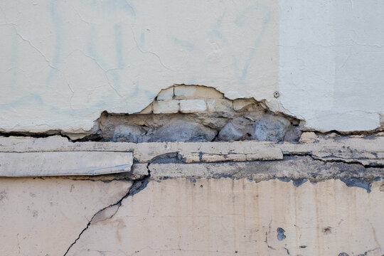 A wall with a broken piece of concrete on it