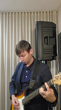homem musico tocando guitarra em est&uacute;dio casa