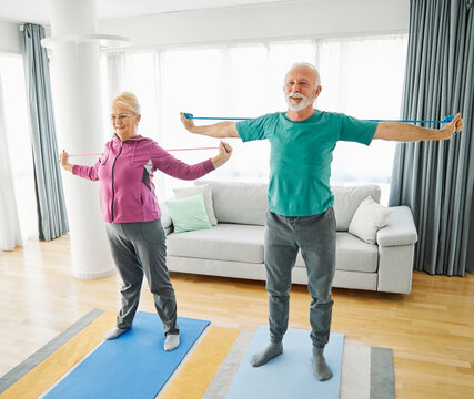 Senior couple exercise stretching resistance band at home, health care and active seniors concept