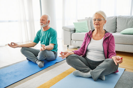Senior couple exercise stretching or doing yoga at home, health care and active seniors concept