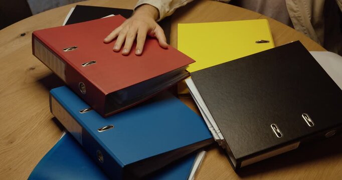 Person overwhelmed by office binders as a Bankruptcy document appears. Ideal for business failure, financial crisis, debt, insolvency and work stress.