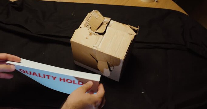 Damaged parcel inspected and placed on Quality Hold. Ideal for quality control, shipping damage, rejected goods, inspection and logistics.