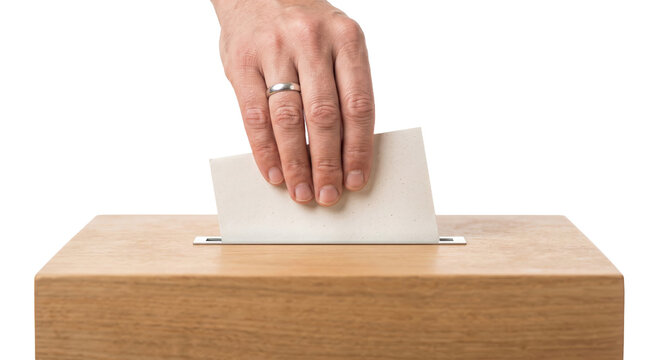 Hand casting a ballot into a wooden ballot box during an election