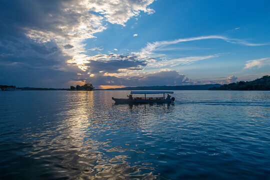 Boat transport on Peten Itza Lake at sunset, Flores, Guatemala.