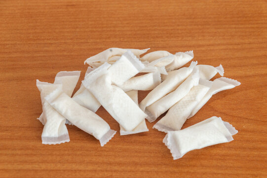 Manu nicotine snus bags on wooden table.