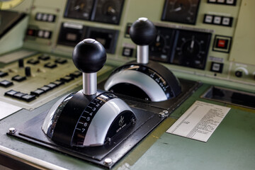 Ship control levers with gauges and dials on a bridge control panel, showing the navigation equipment of a working vessel © Татьяна Швец