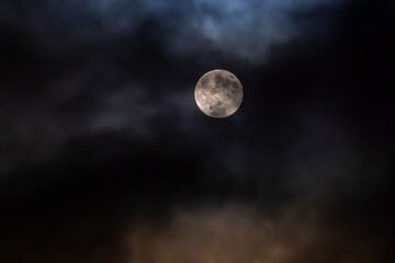Full moon amidst clouds in the night sky © Ivan_Gatsenko