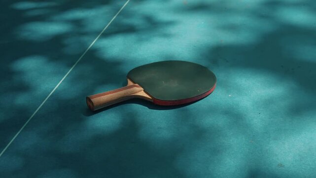 Table tennis paddle bat on a blue table, ping pong bat